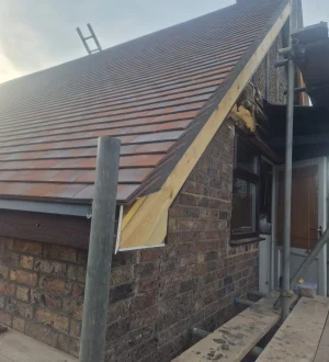 Professional Tile Roofing Services | Durable & Weatherproof Expert roofing technician installing clay tiles on a London home